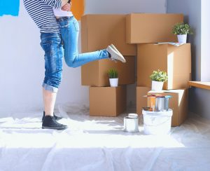 a woman standing in front of a pile of boxes.